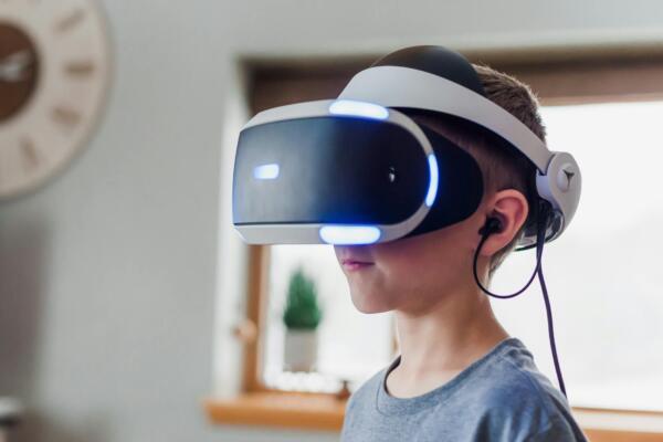 boy wearing black and white virtual reality headset